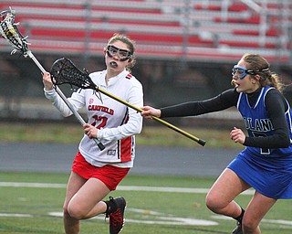 William D. Lewis The vindicator  Canfield's Alli wilson(12) moves the ball past Poalnds Sarah Leach(7) during 4-5-19 game with Poland.