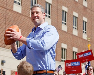 Tim Ryan prepares to throw a football into the crowd during his presidential kickoff rally on Federal Street Saturday afternoon. EMILY MATTHEWS | THE VINDICATOR