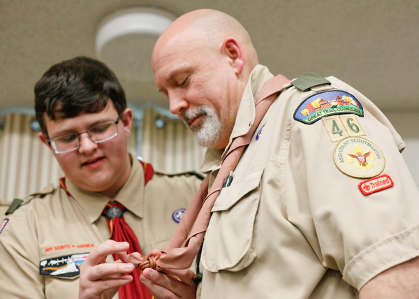 Don Wittman receives his wood badge and his son David Wittman, 17, helps him put a knot on his neckerchief at the Whispering Pines Recognition Dinner in St. James Episcopal Church in Boardman on Sunday. EMILY MATTHEWS | THE VINDICATOR