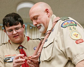 Don Wittman receives his wood badge and his son David Wittman, 17, helps him put a knot on his neckerchief at the Whispering Pines Recognition Dinner in St. James Episcopal Church in Boardman on Sunday. EMILY MATTHEWS | THE VINDICATOR