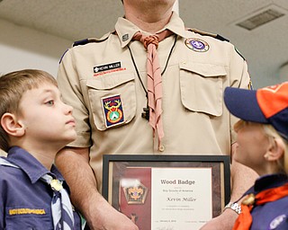 Kevin Miller stands with two of his children, Reece Miller, 9, left, and Willow, 7, after receiving his Wood Badge at the Whispering Pines Recognition Dinner in St. James Episcopal Church in Boardman on Sunday. EMILY MATTHEWS | THE VINDICATOR