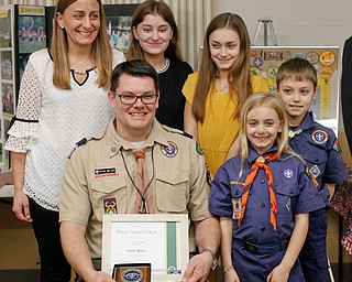 Kevin Miller holds his District Award of Merit as his family, including his wife Julie Miller and children Riley Miller, 14, Whitney Miller, 11, Willow Miller, 7, and Reece Miller, 9, stand around him at the Whispering Pines Recognition Dinner in St. James Episcopal Church in Boardman on Sunday. EMILY MATTHEWS | THE VINDICATOR