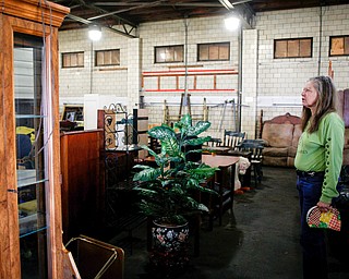 Diane Less, director of Angels for Animals, stands among furniture that will be for sale at the Angels for Animals garage sale at the Canfield Fairgrounds on Tuesday morning. The garage sale will take place Friday through Sunday at the fairgrounds. EMILY MATTHEWS | THE VINDICATOR