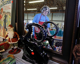 Mickey Cope Weaver, of Salem, arranges antiques that will be for sale in the antique room at the Angels for Animals garage sale at the Canfield Fairgrounds on Tuesday morning. The garage sale will take place Friday through Sunday at the fairgrounds. EMILY MATTHEWS | THE VINDICATOR