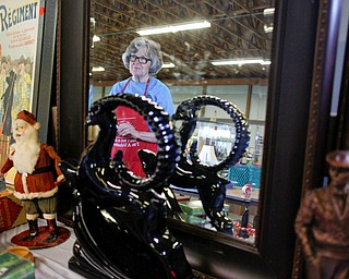 Mickey Cope Weaver, of Salem, arranges antiques that will be for sale in the antique room at the Angels for Animals garage sale at the Canfield Fairgrounds on Tuesday morning. The garage sale will take place Friday through Sunday at the fairgrounds. EMILY MATTHEWS | THE VINDICATOR