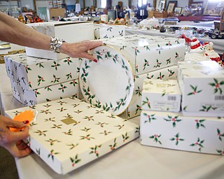 Mickey Cope Weaver, of Salem, arranges antique china sets that will be for sale in the antique room at the Angels for Animals garage sale at the Canfield Fairgrounds on Tuesday morning. The garage sale will take place Friday through Sunday at the fairgrounds. EMILY MATTHEWS | THE VINDICATOR