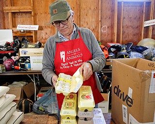 Volunteer Bill Varga, of Columbiana, arranges golf balls and other sports equipment that will be for sale at the Angels for Animals garage sale at the Canfield Fairgrounds on Tuesday morning. The garage sale will take place Friday through Sunday at the fairgrounds. EMILY MATTHEWS | THE VINDICATOR