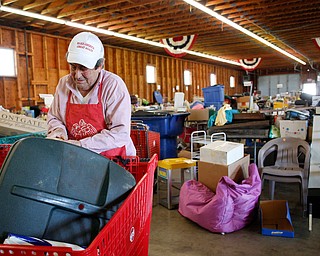 Volunteer Sonny Nabb, of Boardman, arranges items that will be for sale at the Angels for Animals garage sale at the Canfield Fairgrounds on Tuesday morning. The garage sale will take place Friday through Sunday at the fairgrounds. EMILY MATTHEWS | THE VINDICATOR