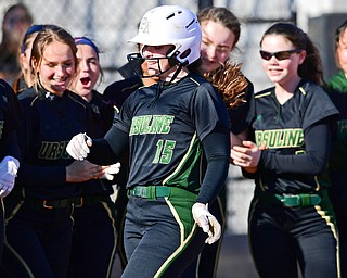 Ursuline High School's Emily Holland is congratulated by her teammates after belting a solo home run in the second inning of Tuesday's softball game against rival Cardinal Mooney at Youngstown State University's Covelli Sports Complex. The Irish won 11-1.