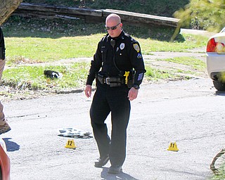 City police mark the shell casings found in the 100 block of Tod Lane after a shooting Tuesday. The Mahoning County Coroner's office Wednesday identified the shooting victim as Savon Young, 25. 