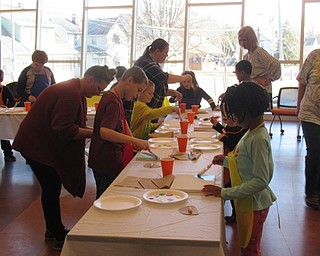 Neighbors | Jessica Harker.Children carefully painted their canvases along with librarian assistant Amelia Dale at the Michael Kusalaba library on March 12.