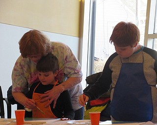 Neighbors | Jessica Harker.Ginger Zink assisted her grandsons, Jack and Izzy Zink, as they painted their canvases on March 12 at the first Sip and Paint for children.