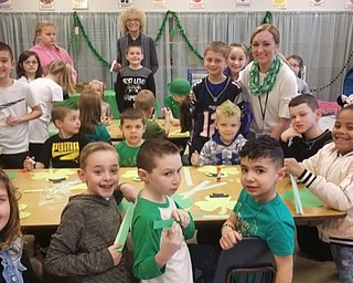 Neighbors | Submitted.Preschool teacher Joye Bucci (back left) and student teacher Amber Wagner (front right) posed with students as they worked on shamrock crafts to donate to Meridian Arms nursing home.