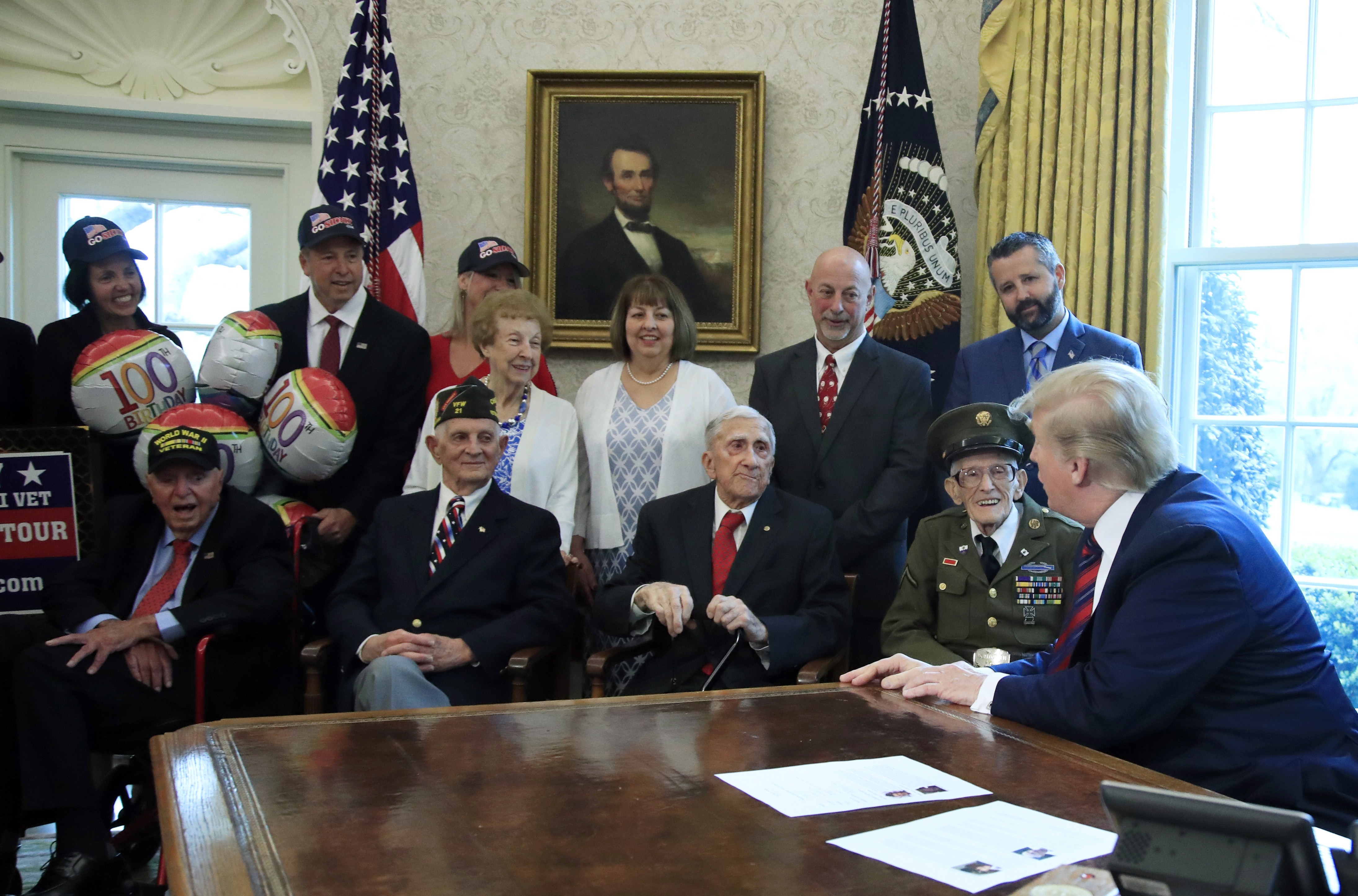 President Donald Trump is joined by World War II veterans, seated from left, Sidney Walton, Allen Jones, Paul Kriner and Floyd Wigfield, in the Oval Office of the White House in Washington, Thursday, April 11, 2019.