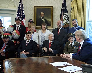 President Donald Trump is joined by World War II veterans, seated from left, Sidney Walton, Allen Jones, Paul Kriner and Floyd Wigfield, in the Oval Office of the White House in Washington, Thursday, April 11, 2019.