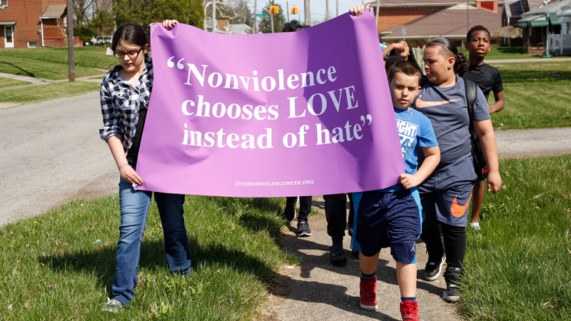 Mackenzie Kowal, left, 10; Edward Bevly, 9; James Bevly, 11; and Trevon Wilkens, 10, lead a group of children and adults as they march around Taft Elementary School on the South Side during one of the four Crime-Free Zone rallies in Youngstown on Saturday afternoon. 