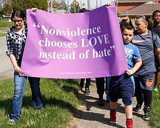 Mackenzie Kowal, left, 10; Edward Bevly, 9; James Bevly, 11; and Trevon Wilkens, 10, lead a group of children and adults as they march around Taft Elementary School on the South Side during one of the four Crime-Free Zone rallies in Youngstown on Saturday afternoon. 
