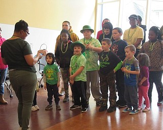 Neighbors | Jessica Harker.Librarian Rhonda Monroe explained the rules of a game to the children gathered at the Michael Kusalaba Green Party on March 16.