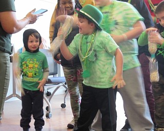 Neighbors | Jessica Harker.Community member Jack Zink shook a bottle full of Lucky Charms while competeing in a game at the Michael Kusalaba Green Party to celebrate St. Patrick's Day.