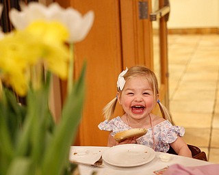 Claire Hawks, 2, of Canfield, smiles as she eats a bagel at the annual Easter Brunch at Fellows Riverside Gardens on Sunday. EMILY MATTHEWS | THE VINDICATOR