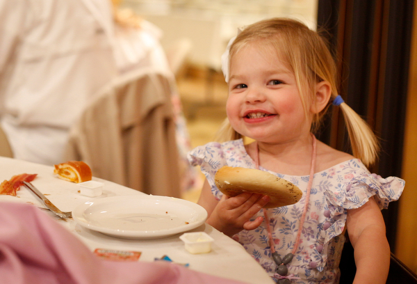 Claire Hawks, 2, of Canfield, smiles as she eats a bagel at the annual Easter Brunch at Fellows Riverside Gardens on Sunday. EMILY MATTHEWS | THE VINDICATOR
