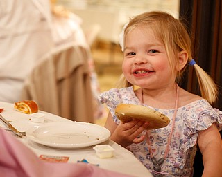 Claire Hawks, 2, of Canfield, smiles as she eats a bagel at the annual Easter Brunch at Fellows Riverside Gardens on Sunday. EMILY MATTHEWS | THE VINDICATOR