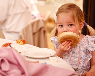 Claire Hawks, 2, of Canfield, eats a bagel at the annual Easter Brunch at Fellows Riverside Gardens on Sunday. EMILY MATTHEWS | THE VINDICATOR