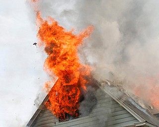 Firefighters work to put out a house fire on Wilson Avenue on Wednesday afternoon. EMILY MATTHEWS | THE VINDICATOR