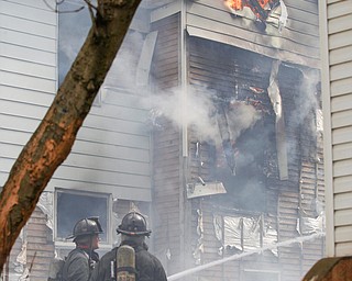 Firefighters work to put out a house fire on Wilson Avenue on Wednesday afternoon. EMILY MATTHEWS | THE VINDICATOR