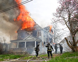 Firefighters work to put out a house fire on Wilson Avenue on Wednesday afternoon. EMILY MATTHEWS | THE VINDICATOR