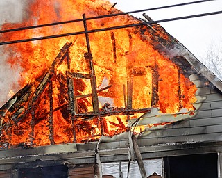 Firefighters work to put out a house fire on Wilson Avenue on Wednesday afternoon. EMILY MATTHEWS | THE VINDICATOR