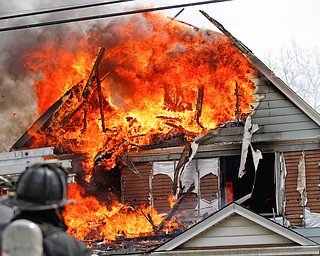 Firefighters work to put out a house fire on Wilson Avenue on Wednesday afternoon. EMILY MATTHEWS | THE VINDICATOR