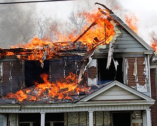 Firefighters work to put out a house fire on Wilson Avenue on Wednesday afternoon. EMILY MATTHEWS | THE VINDICATOR