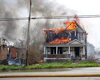 Firefighters work to put out a house fire on Wilson Avenue on Wednesday afternoon. EMILY MATTHEWS | THE VINDICATOR