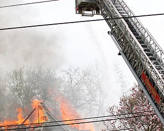 Firefighters work to put out a house fire on Wilson Avenue on Wednesday afternoon. EMILY MATTHEWS | THE VINDICATOR