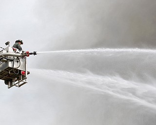 Firefighters work to put out a house fire on Wilson Avenue on Wednesday afternoon. EMILY MATTHEWS | THE VINDICATOR