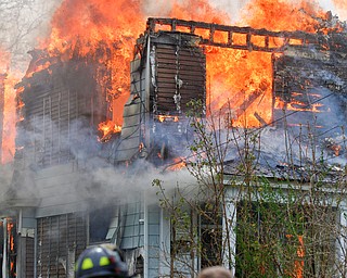 Firefighters work to put out a house fire on Wilson Avenue on Wednesday afternoon. EMILY MATTHEWS | THE VINDICATOR