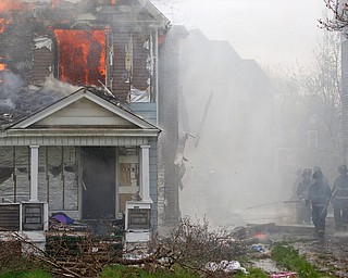 Firefighters work to put out a house fire on Wilson Avenue on Wednesday afternoon. EMILY MATTHEWS | THE VINDICATOR