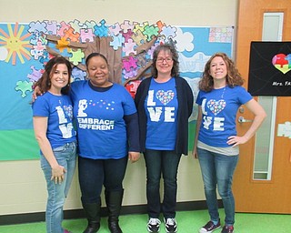 Neighbors | Jessica Harker .Holly Fay (left), the teacher of the Lighthouse Unit at Austintown Elementary School, and her team of paraprofessionals posed on April 2 for Austism Awareness Day.