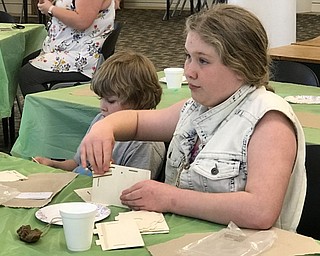 Neighbors | Jessica Harker.Community members used sandpaper to smooth down the rough edges of their birdhouses on April 17 at the Austintown library.
