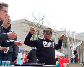 Christopher McDuffie, 9, of Youngstown, tries to form big bubbles with the help of Nathan Williams, left, a sophomore studying biochemistry at YSU, and Dr. Mike Serra, biochemistry professor at YSU, at the YSU's chapter of the American Chemical Society's table at Federal Frenzy on Saturday. EMILY MATTHEWS | THE VINDICATOR