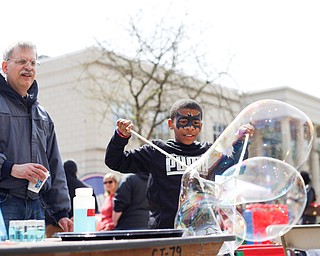 Christopher McDuffie, 9, of Youngstown, forms big bubbles while Dr. Mike Serra, biochemistry professor at YSU, watches at the YSU's chapter of the American Chemical Society's table at Federal Frenzy on Saturday. EMILY MATTHEWS | THE VINDICATOR