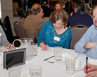 From left, Adrienne Mackall, Dorothy Vernarsky, David Vernarsky, and Mary Roth, all friends of Loraine Lynn who said they played cards with her for 35 years, write down happy memories they have of her. They attended a memorial event to celebrate her life at Vernon's Cafe on Saturday.  