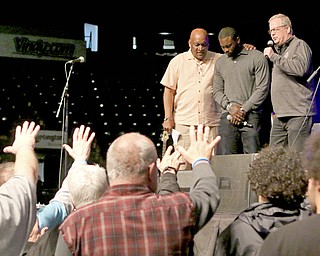 Michael Vick, center stage, is flanked by Pastor Gary Frost, left, and Jonathan Moore during Saturday’s 10th annual Men’s Rally In the Valley at the Covelli Centre. Vick, a former quarterback for the Atlanta Falcons and Philadelphia Eagles, said he found purpose in life while serving two years in prison for his role in operating a dog fighting ring. Since then, he’s been dogged by criticism from animal rights advocates, and his appearance at Saturday’s rally was no exception.
