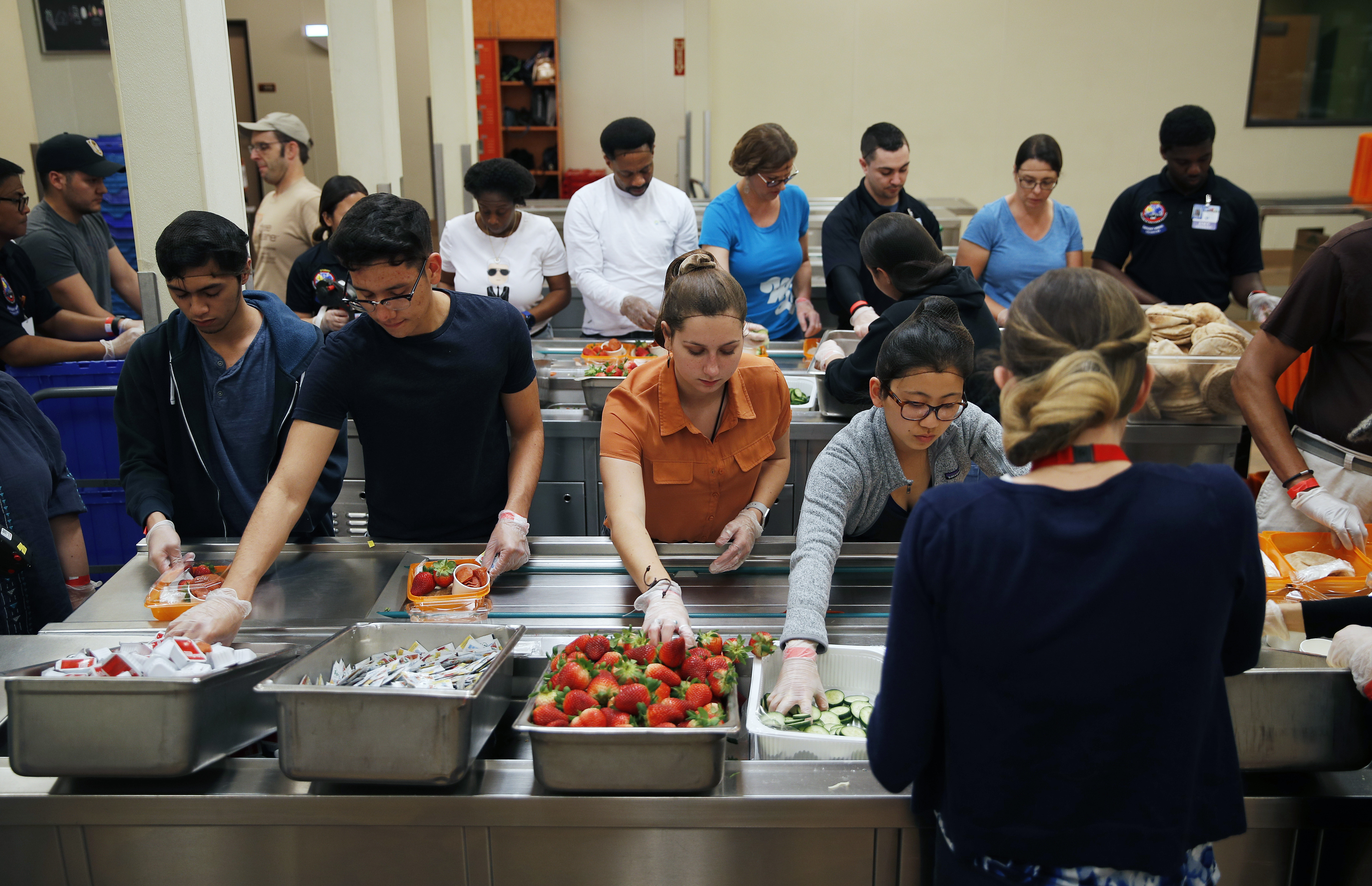 In this March 26, 2019, photo, volunteers put together food trays at Three Square, a food bank in Las Vegas. The reduction of food waste has taken hold in a city known for excess: Las Vegas. Sin City’s world-famous casinos in recent years have developed and expanded innovative practices to cut back on the leftover and uneaten food they send to the landfill by thousands of tons a year. In 2016, MGM began donating fully cooked but never-served meals from conventions and other large events to Three Square, southern Nevada’s only food bank.