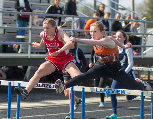 Kiersten Tricker of Badger (left) and Olivia Vanoverbeke of Newton Falls fight stride-for-stride in a 100-meter hurdle semifinal at the Trumbull County Track and Field Meet on Tuesday.