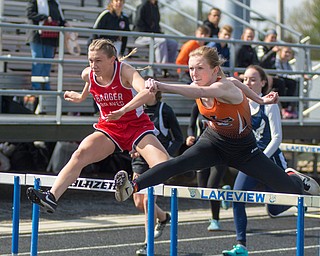 Kiersten Tricker of Badger (left) and Olivia Vanoverbeke of Newton Falls fight stride-for-stride in a 100-meter hurdle semifinal at the Trumbull County Track and Field Meet on Tuesday.