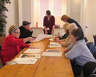 Neighbors | Jessica Harker.Andrea Zupcsan, a librarian at the Austintown library, helped community members learn how to use a grid pattern to draw potraits of photographs April 2.