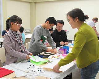 Neighbors | Jessica Harker.Family members worked together to create felt pieces for a storyboard at the Boardman library.