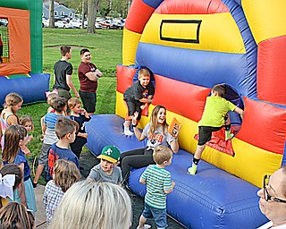 Bella Gentile, a 9th grader at Howland, tells children when it's time for them to enter the blow-up obstacle course outside of Howland High School Thursday evening. The activity was part the "All One" student and community showcase held inside and outside of the high school to celebrate the school district's present and past with an eye toward the future.
